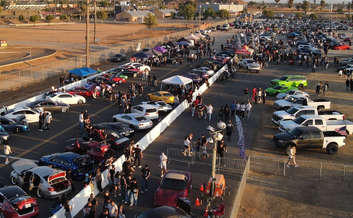 Crowd and cars gathered at the dragway event